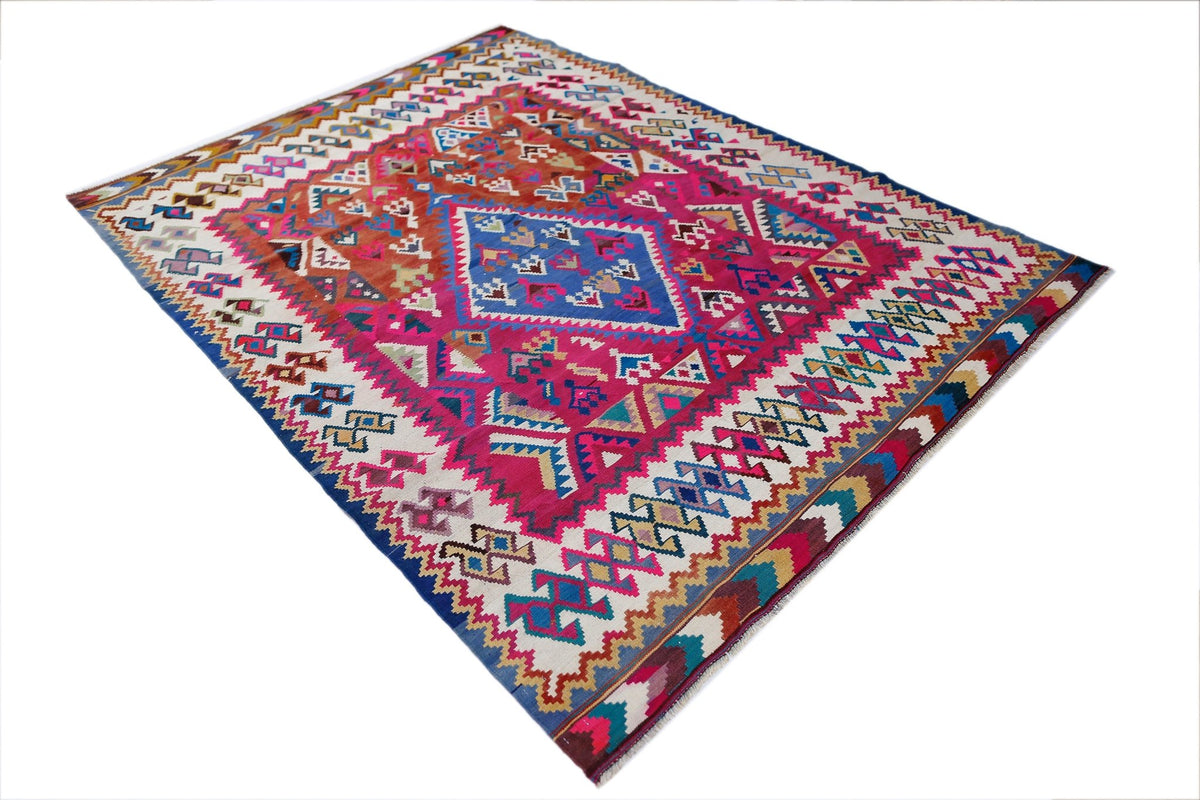 Handwoven Persian Qashqai kilim featuring vibrant pink, blue, and geometric tribal patterns on a cream wool background.