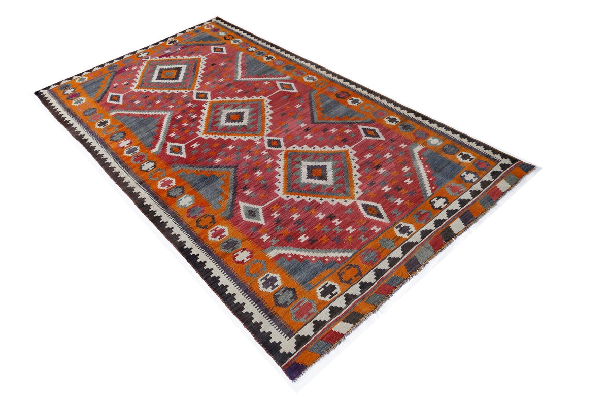 Handwoven Persian Qashqai kilim in red, orange, and grey with geometric diamond patterns and a flat-weave wool texture.