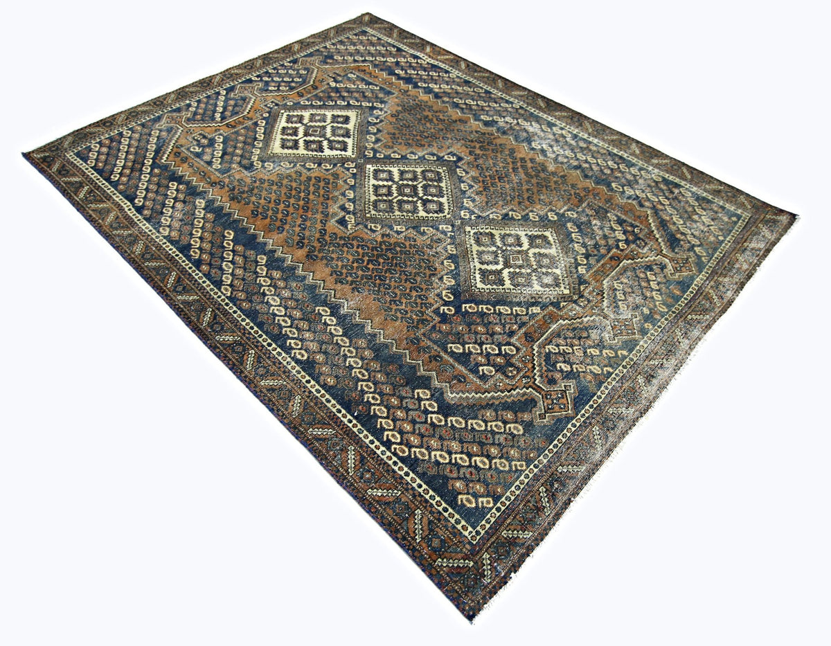 Vintage Persian Qashqai rug in blue and brown with geometric diamond motifs and hand-knotted wool on a cotton foundation.