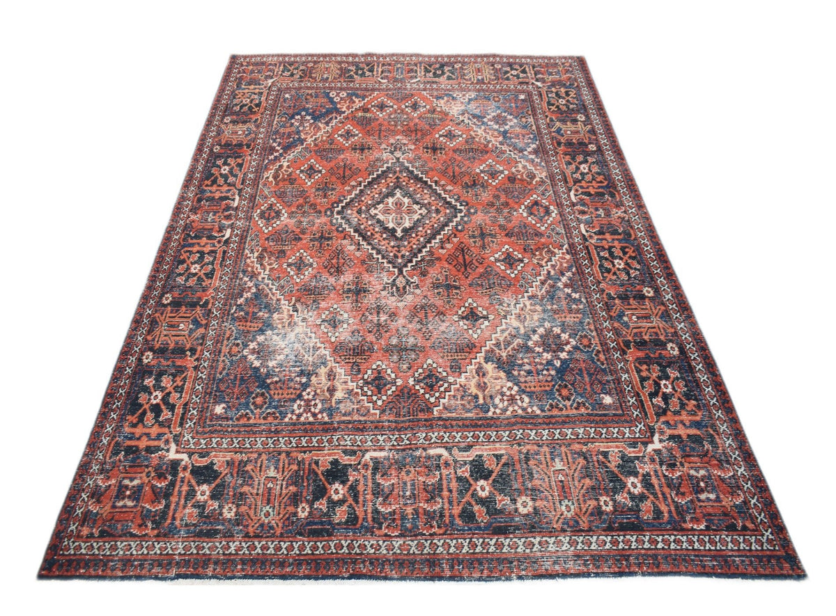A vintage handwoven Persian Ghashghai rug featuring a geometric diamond pattern in red and blue.