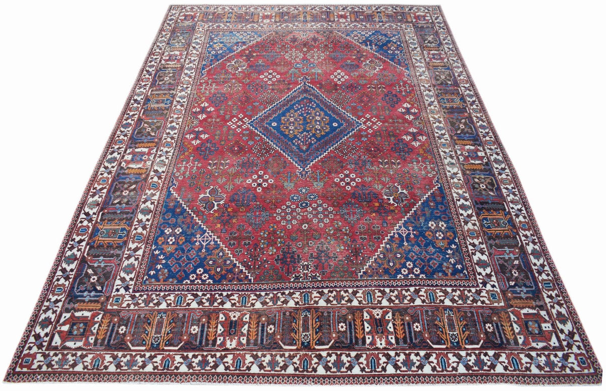 A vintage Persian Ghashghai rug featuring a red field with a blue central medallion and borders.
