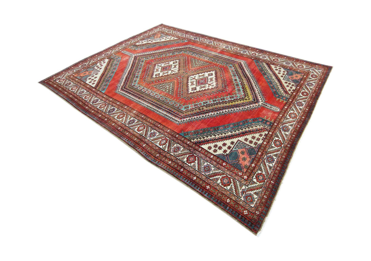 Vintage Persian Qashqai rug in red with intricate geometric patterns, hand-knotted wool, and a central diamond medallion.