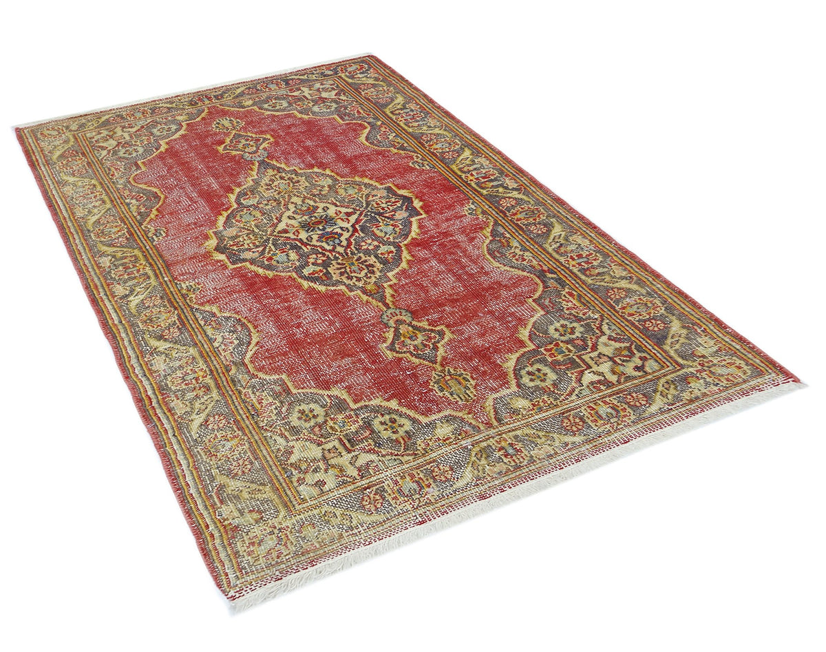 A vintage Persian rug featuring a central medallion pattern in red, beige, and dark grey tones.