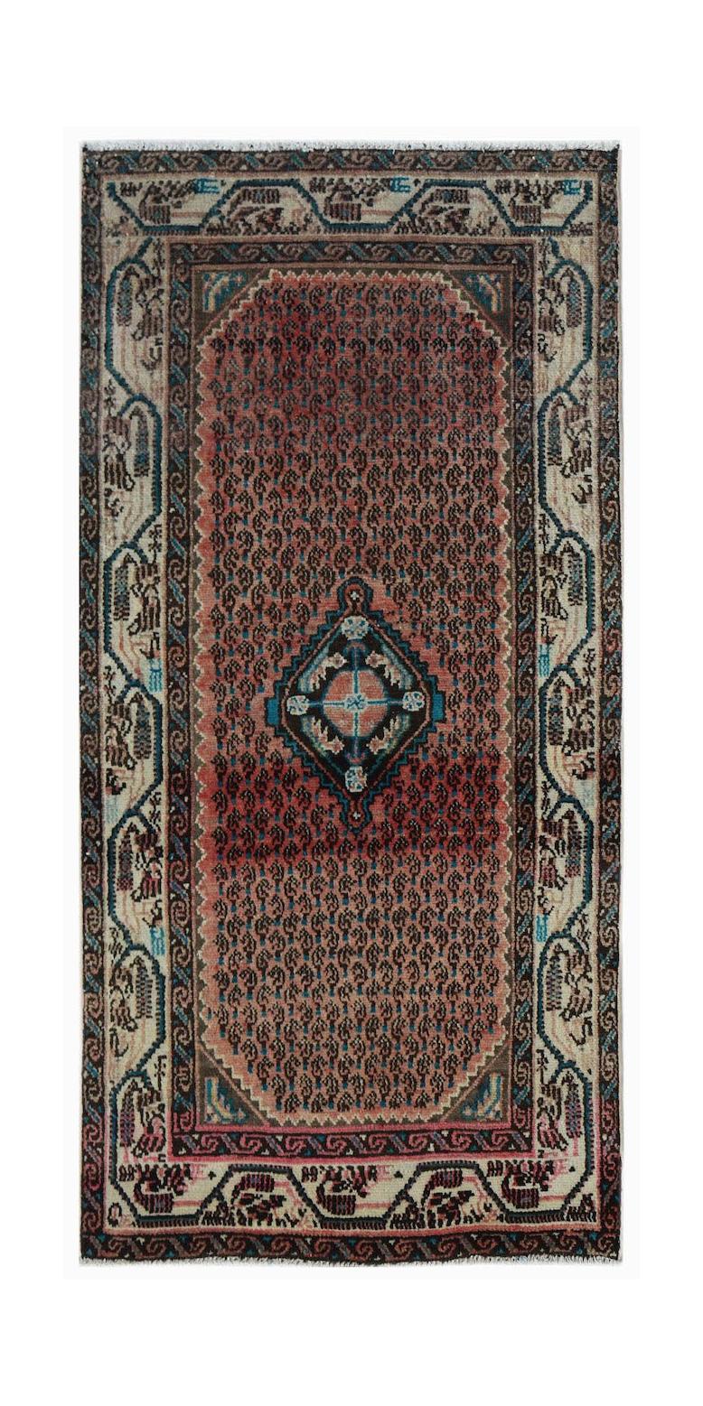 A handwoven vintage Persian rug featuring a central diamond medallion on a patterned red field.