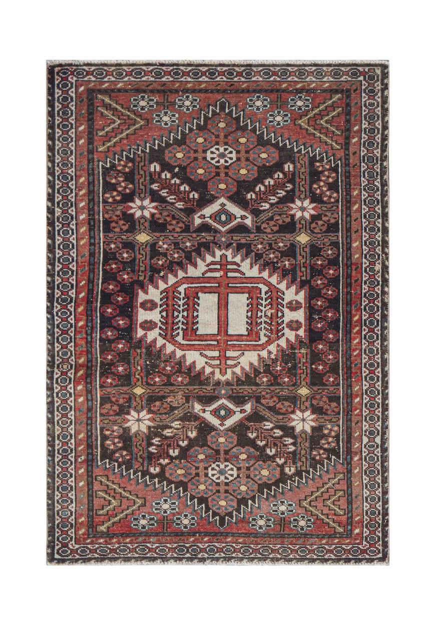 Handwoven vintage Persian rug featuring a geometric medallion pattern in red and dark brown.