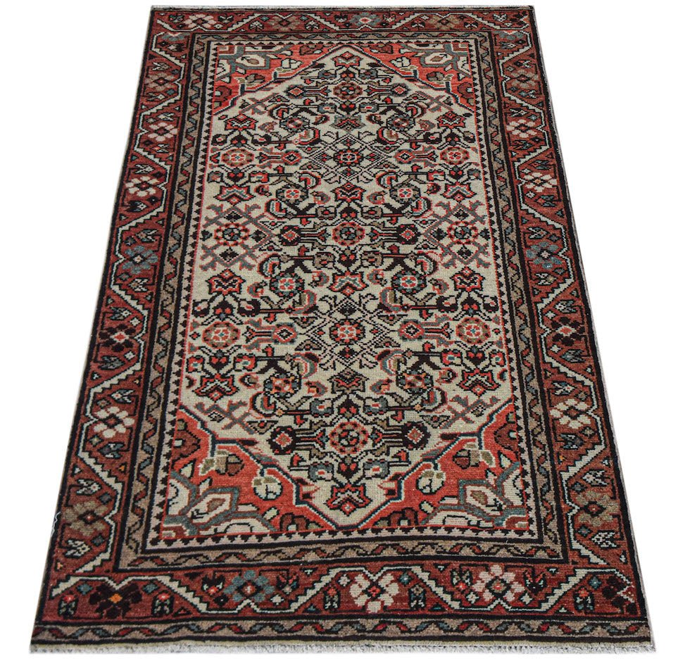 A handwoven vintage Persian rug featuring a central medallion pattern in red, cream, and dark tones.