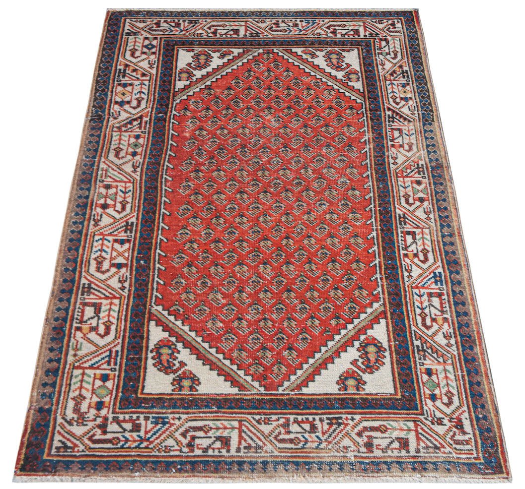Vintage Persian rug with a red diamond pattern and geometric borders.