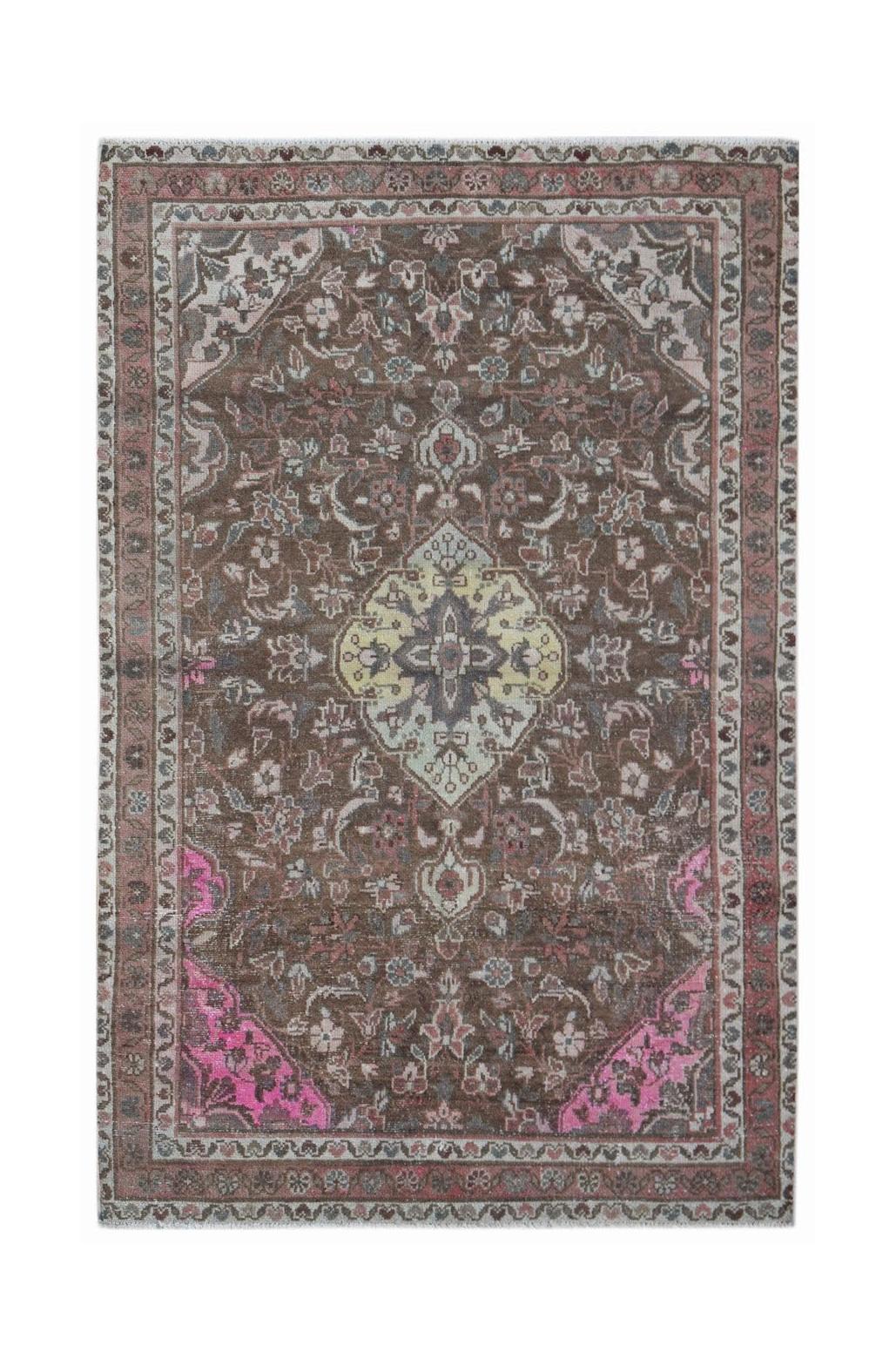 A handwoven vintage Persian rug featuring a central medallion on a brown field with pink accents.