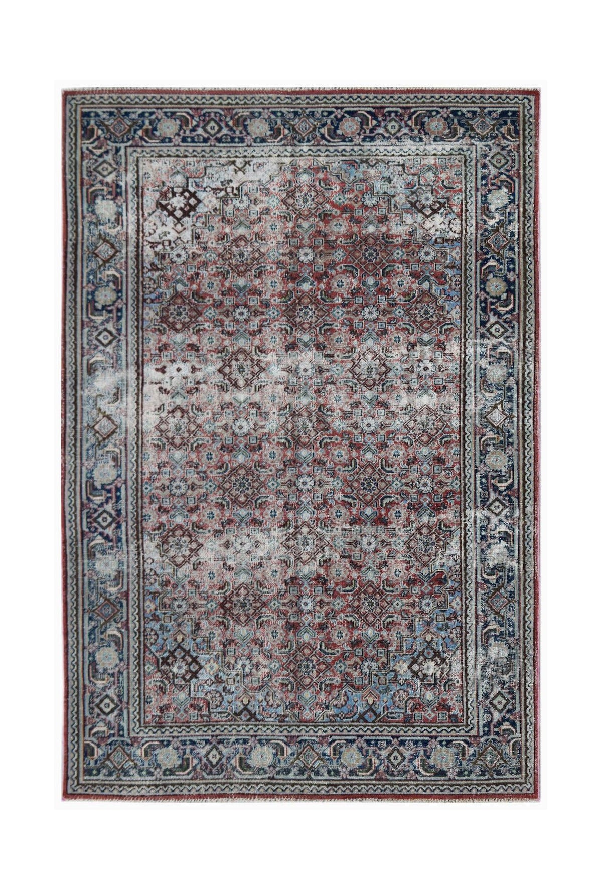A rectangular vintage Persian rug featuring a distressed geometric pattern in red and blue tones.