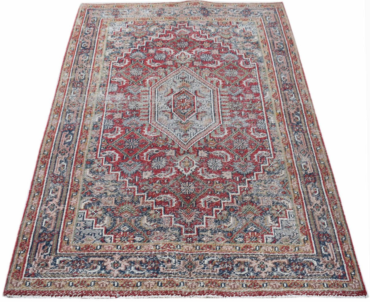 A handwoven vintage Persian rug featuring a traditional red and blue geometric medallion pattern.