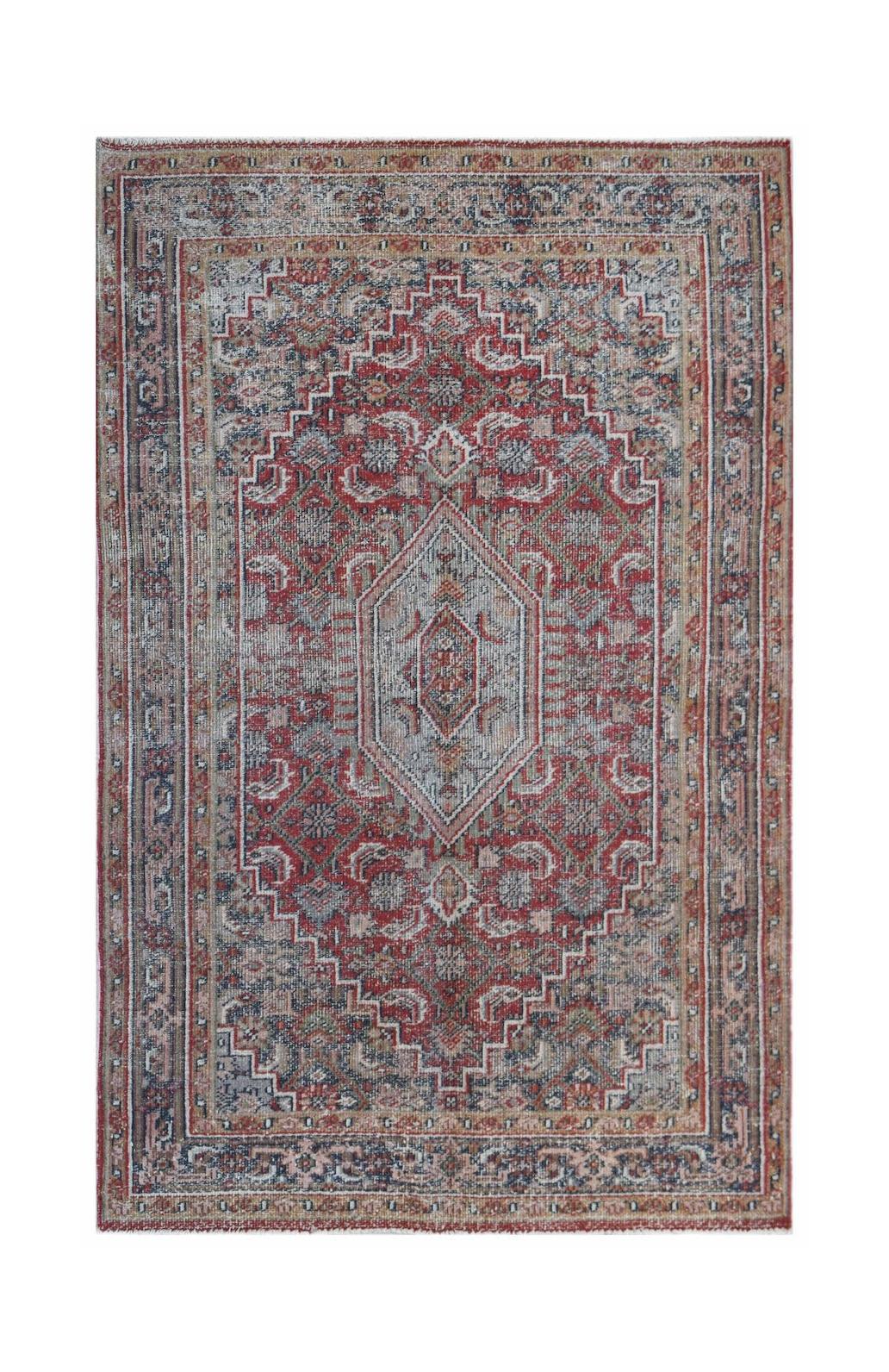 A rectangular vintage Persian rug featuring a central diamond medallion in red, blue, and beige.