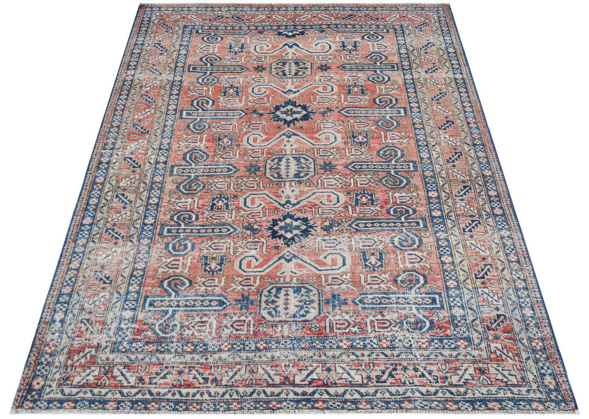 Vintage Persian rug with a coral and blue geometric pattern.
