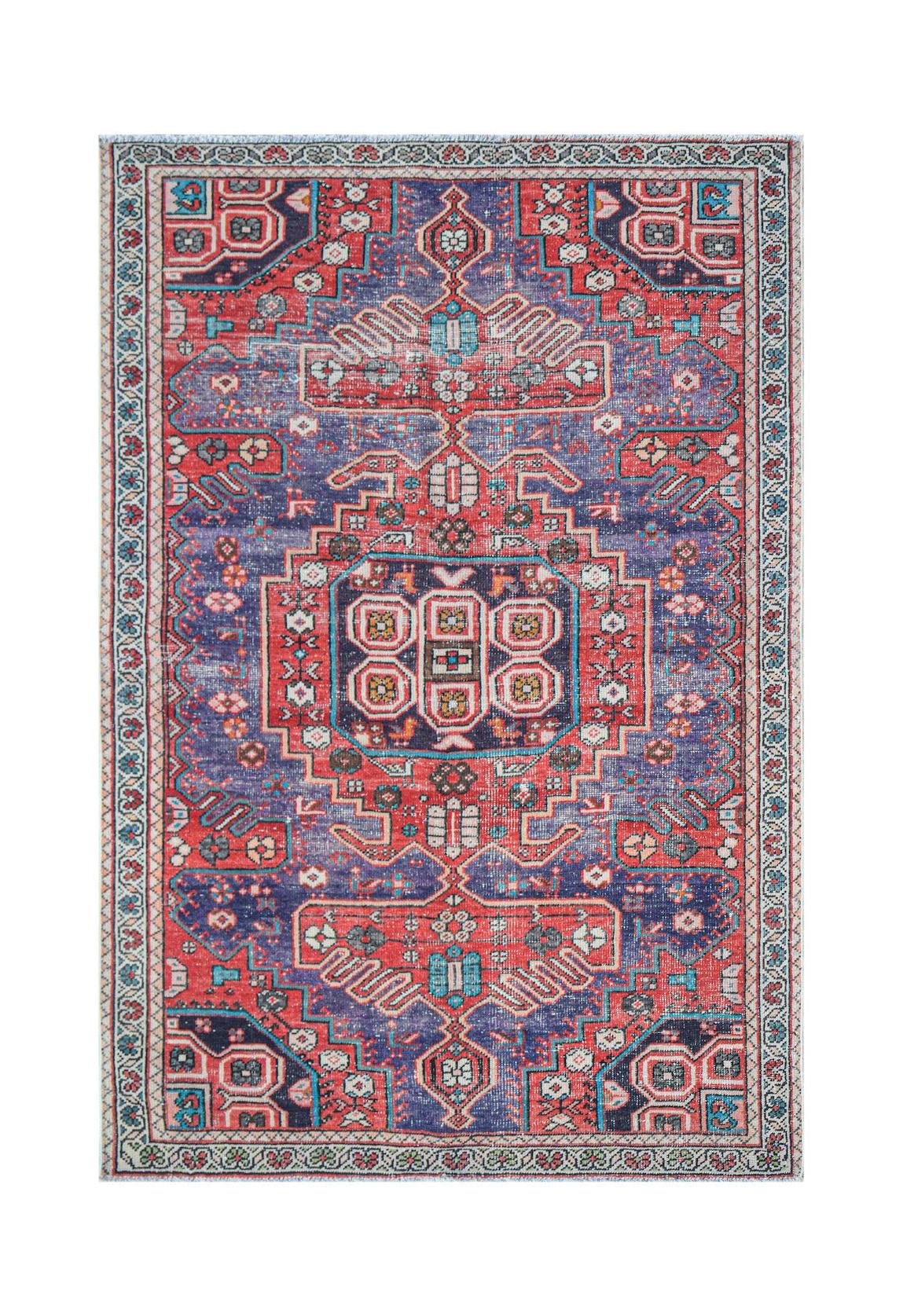 Vintage Persian rug with intricate red, blue, and white geometric patterns.