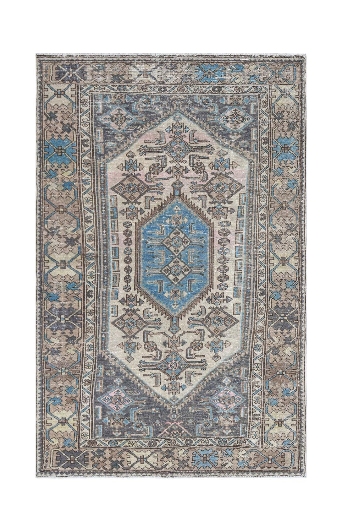Vintage Persian rug with a central blue medallion and geometric patterns.