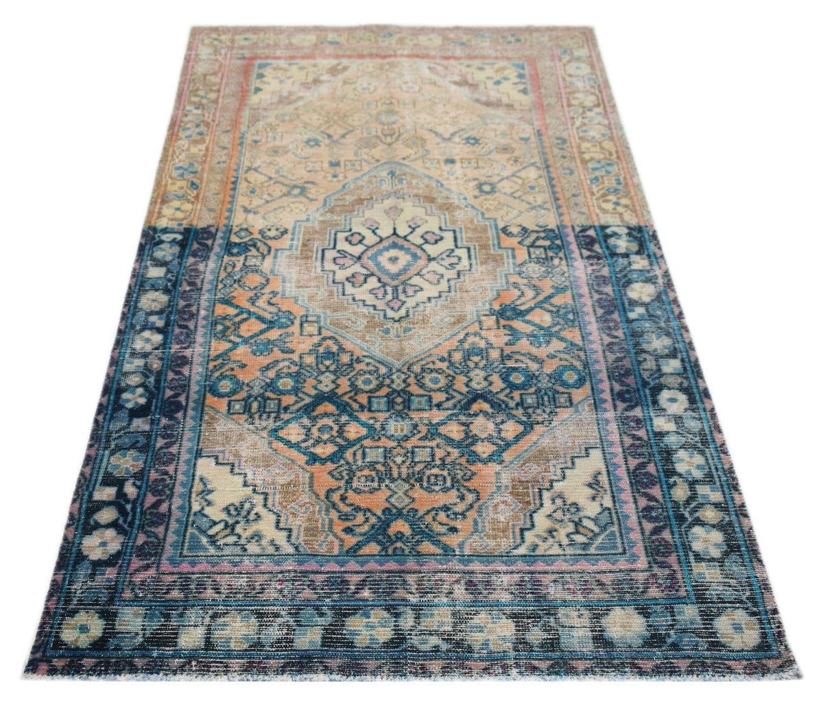 A vintage handwoven Persian rug featuring a central medallion in shades of blue, orange, and beige.