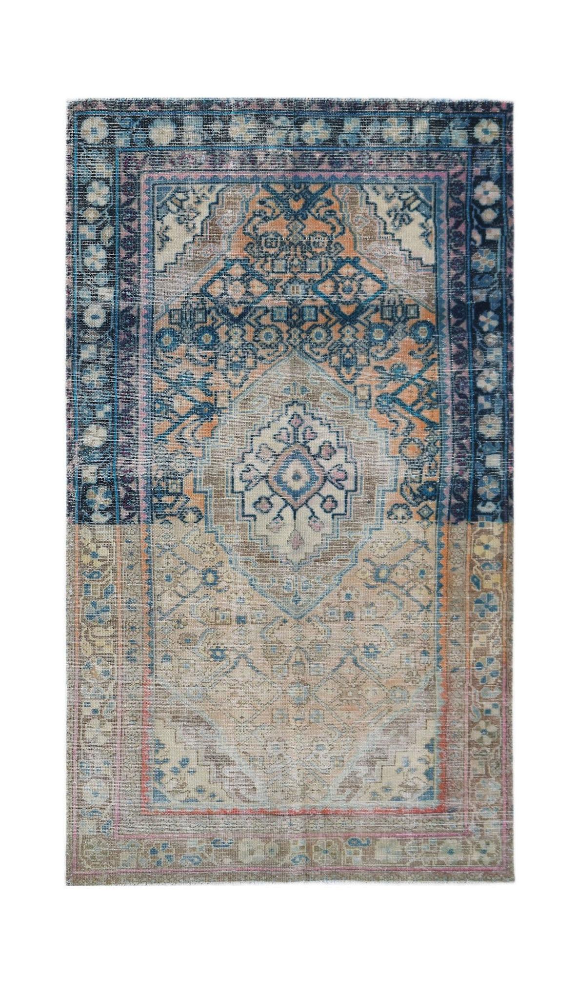 A vintage handwoven Persian rug featuring a central medallion in faded blue, orange, and beige.