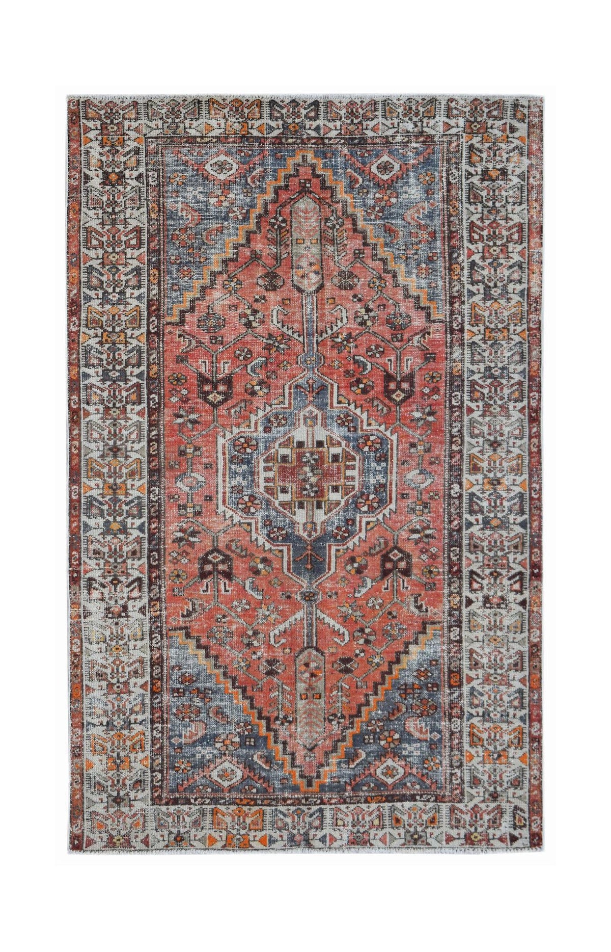 A vintage Persian rug featuring a central medallion in shades of red, blue, and cream.