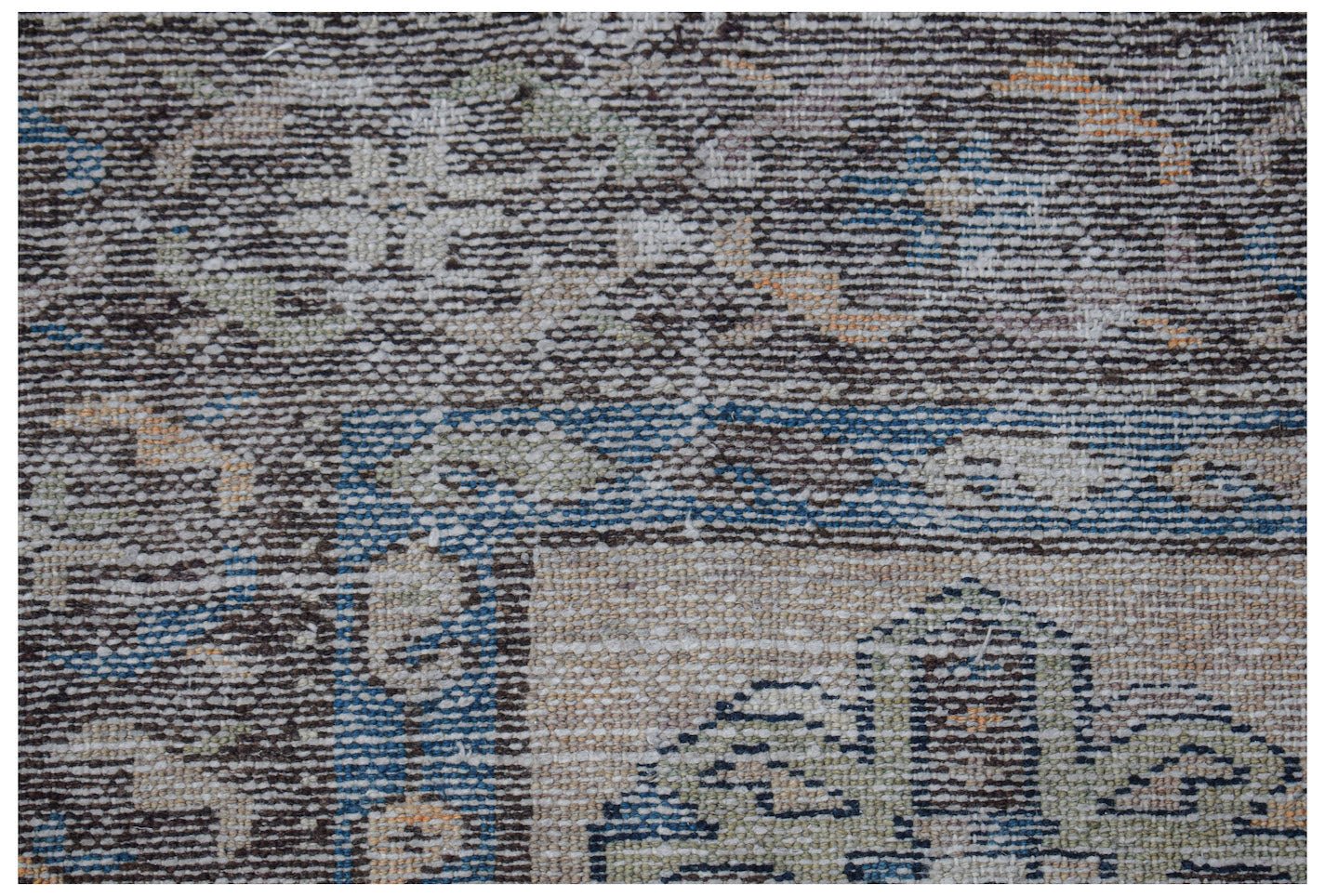Vintage Persian rug with a distressed pattern in muted blues, greens, and oranges.