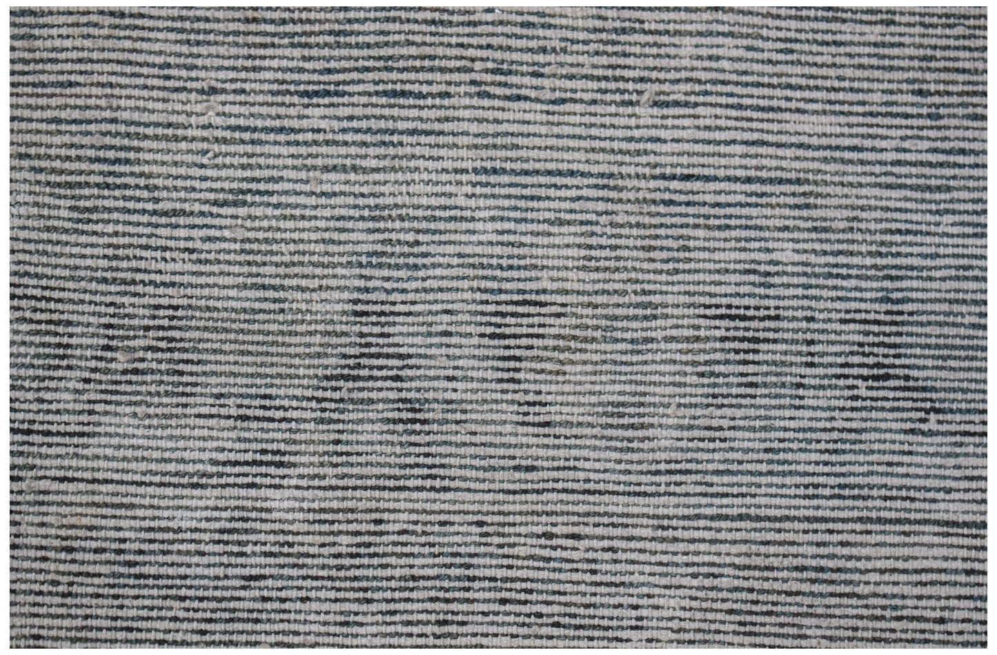 A close-up of a vintage handwoven Turkish rug featuring a textured, striped pattern in muted tones.