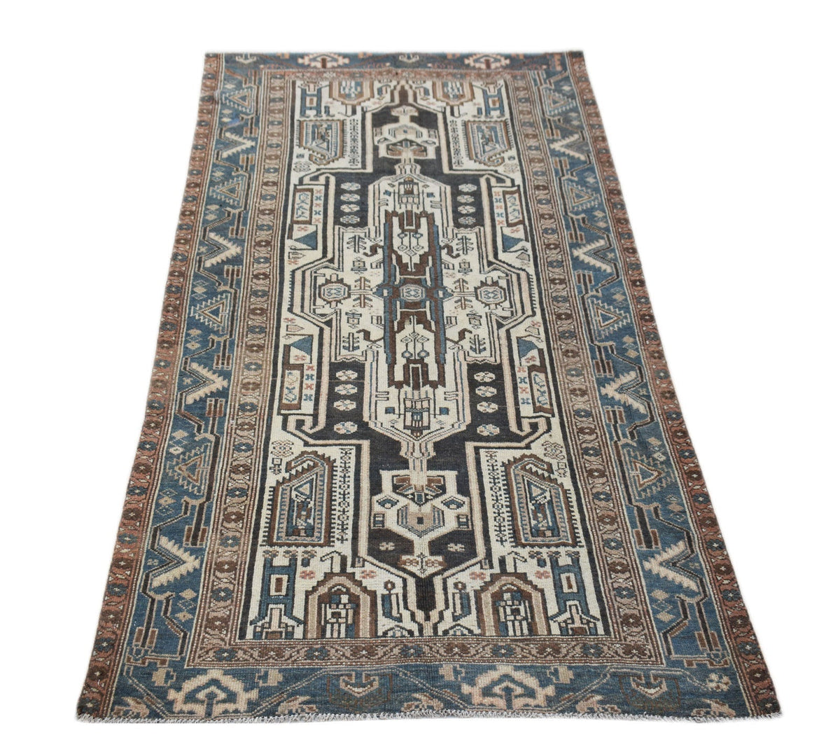 A handwoven vintage Persian rug featuring a geometric medallion pattern in blue, brown, and cream.