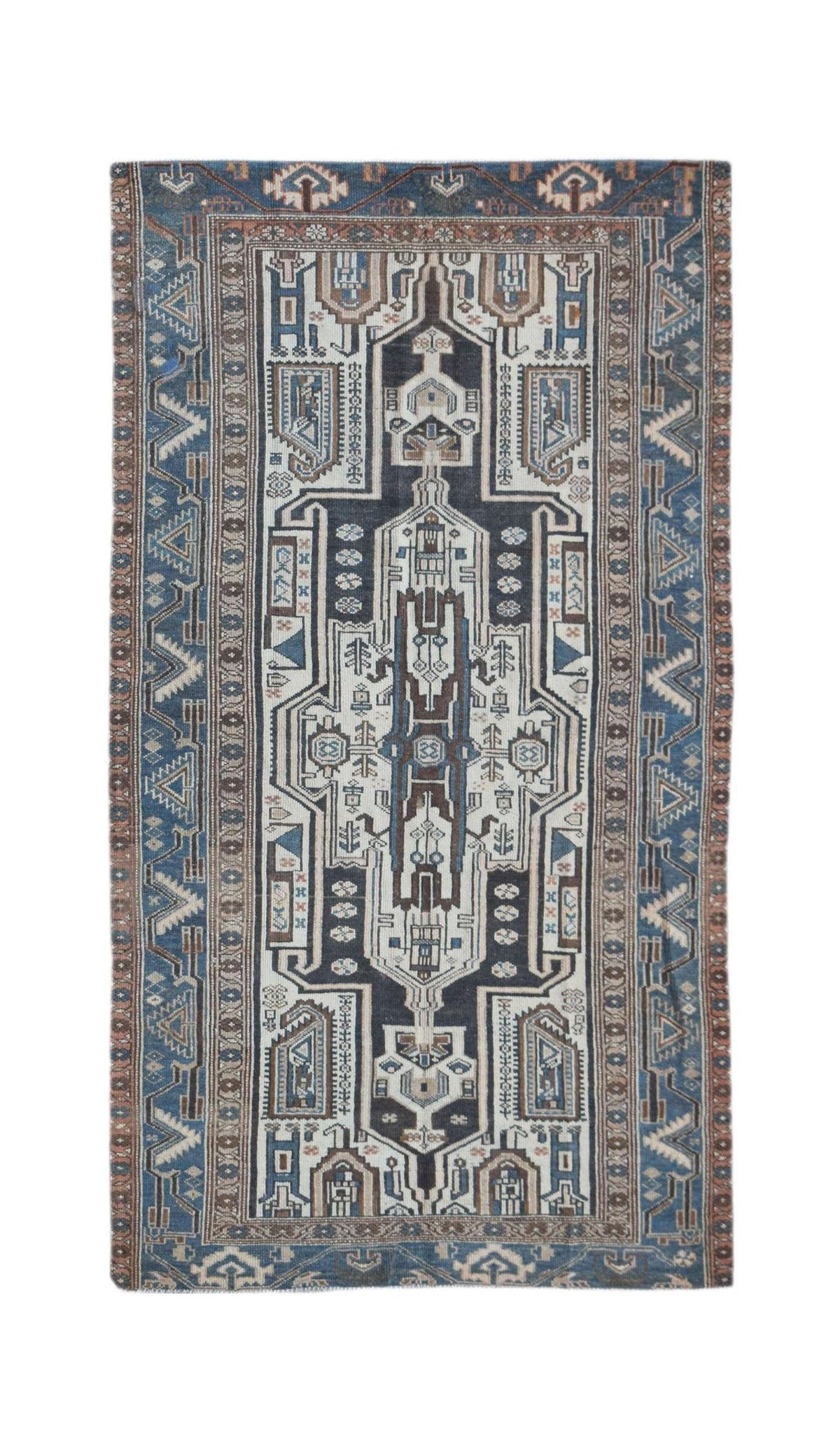 A handwoven vintage Persian rug featuring a geometric central medallion in blue, white, and brown.