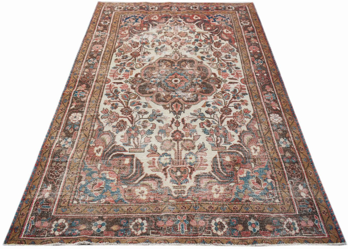 A vintage handwoven Persian rug featuring a floral medallion pattern in muted red and blue tones.