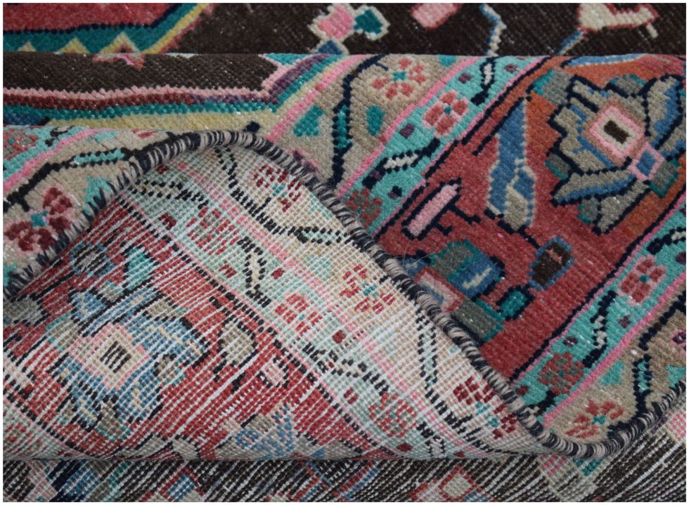 A close-up view of a handmade vintage Persian rug showing its intricate floral pattern and weave.