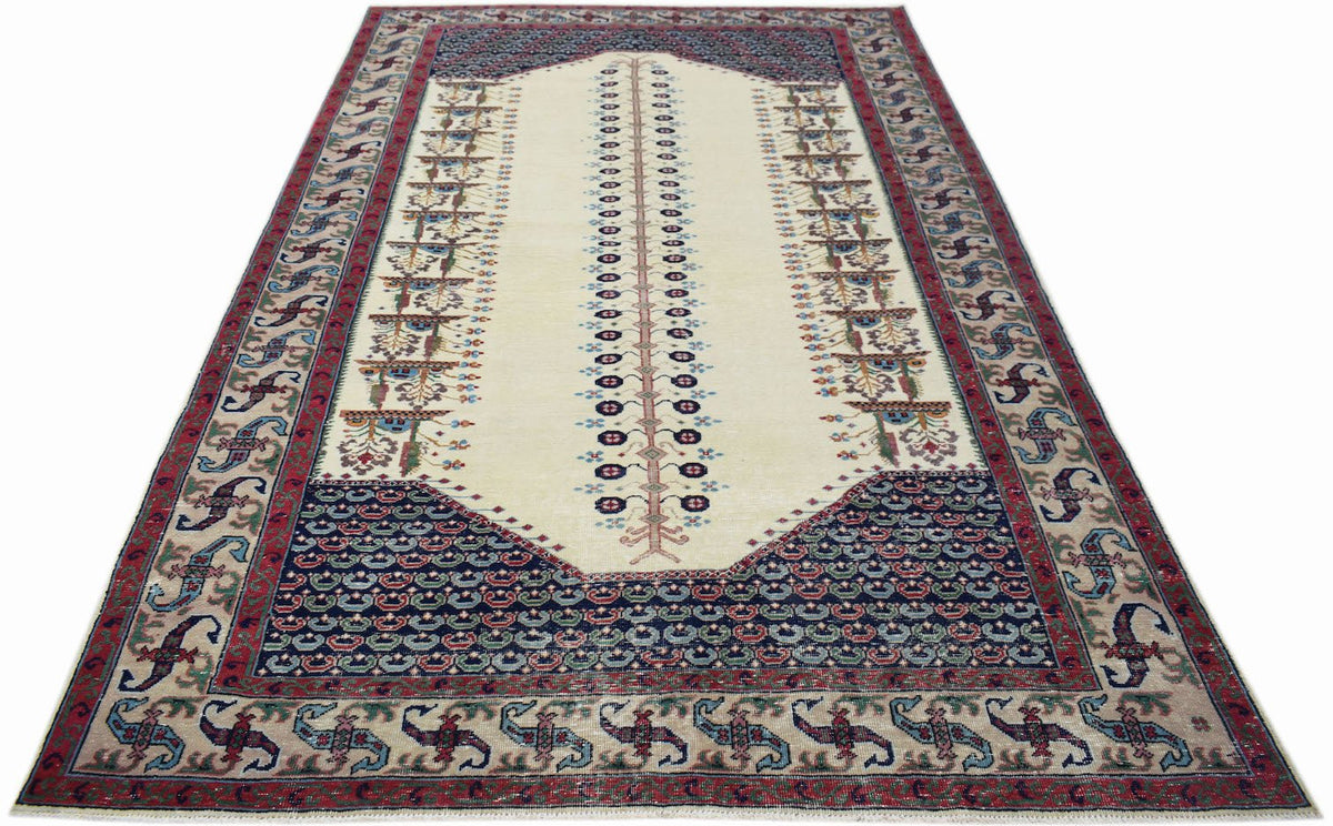 A vintage handwoven Persian rug featuring a central tree motif on a cream field with ornate borders.