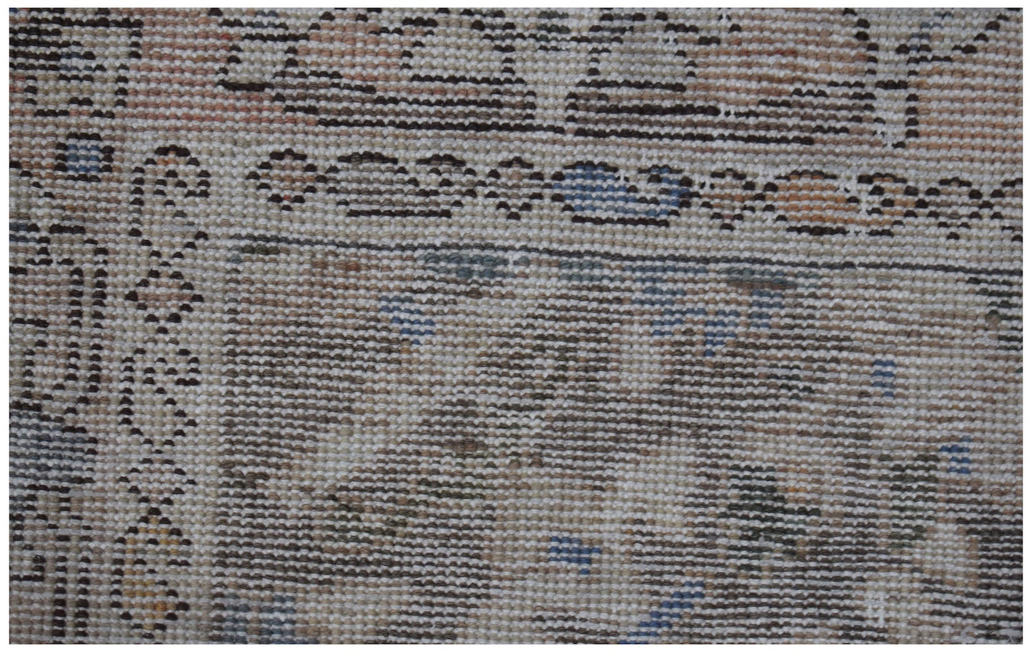 A close-up view of a handwoven vintage Persian rug featuring intricate patterns in muted tones.