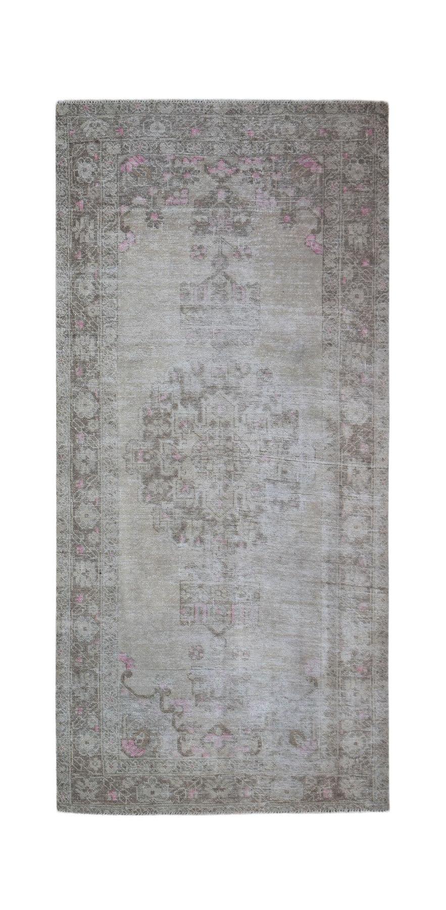 A vintage handwoven Persian runner rug featuring a faded beige pattern with subtle pink accents.