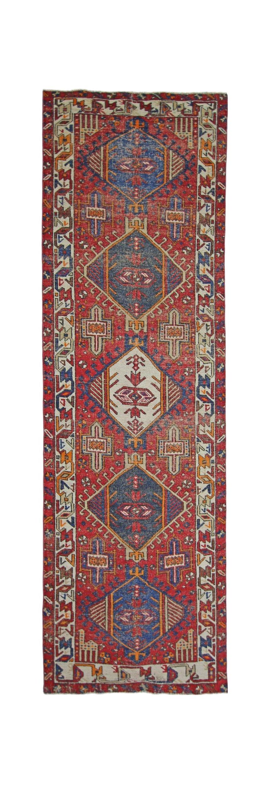 Handmade vintage Persian runner featuring geometric medallions on a vibrant red wool field.