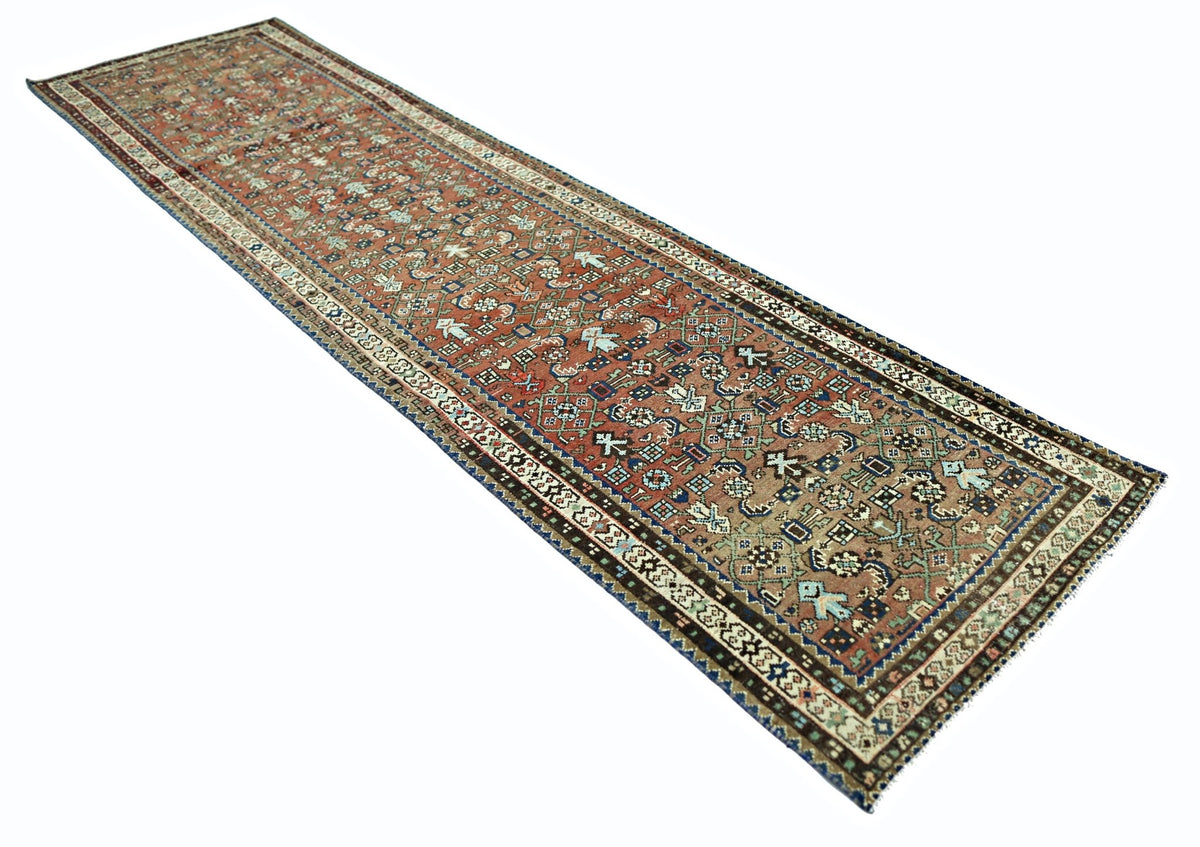 A vintage Persian runner rug featuring intricate geometric patterns in shades of red and blue.
