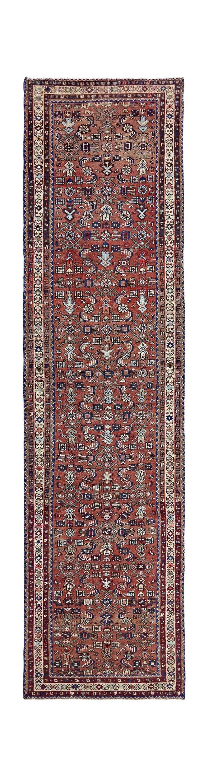 A handmade vintage Persian runner featuring a traditional geometric pattern in red and blue tones.