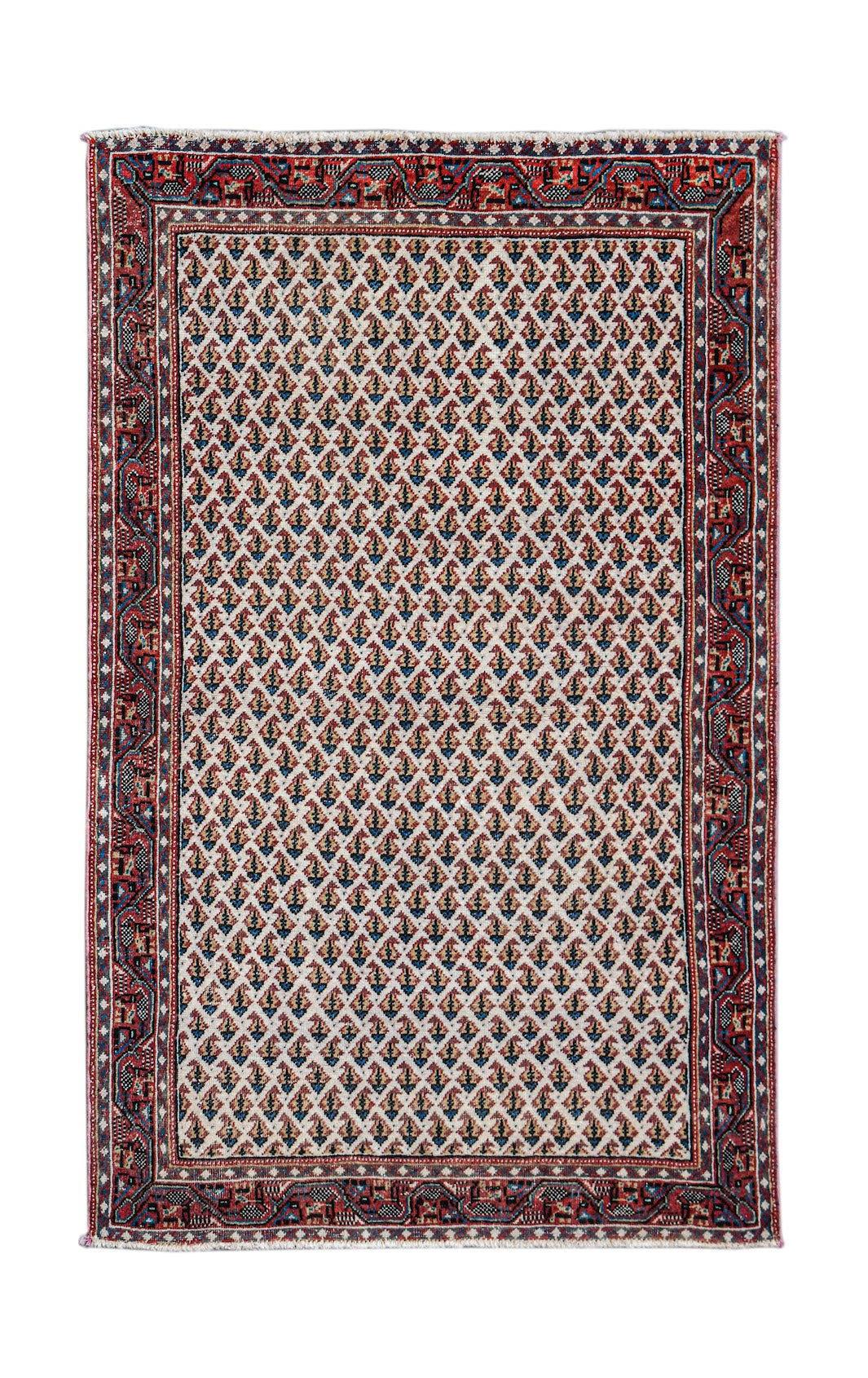 A handwoven vintage Persian Saraband rug featuring a repeating boteh pattern on a cream field.