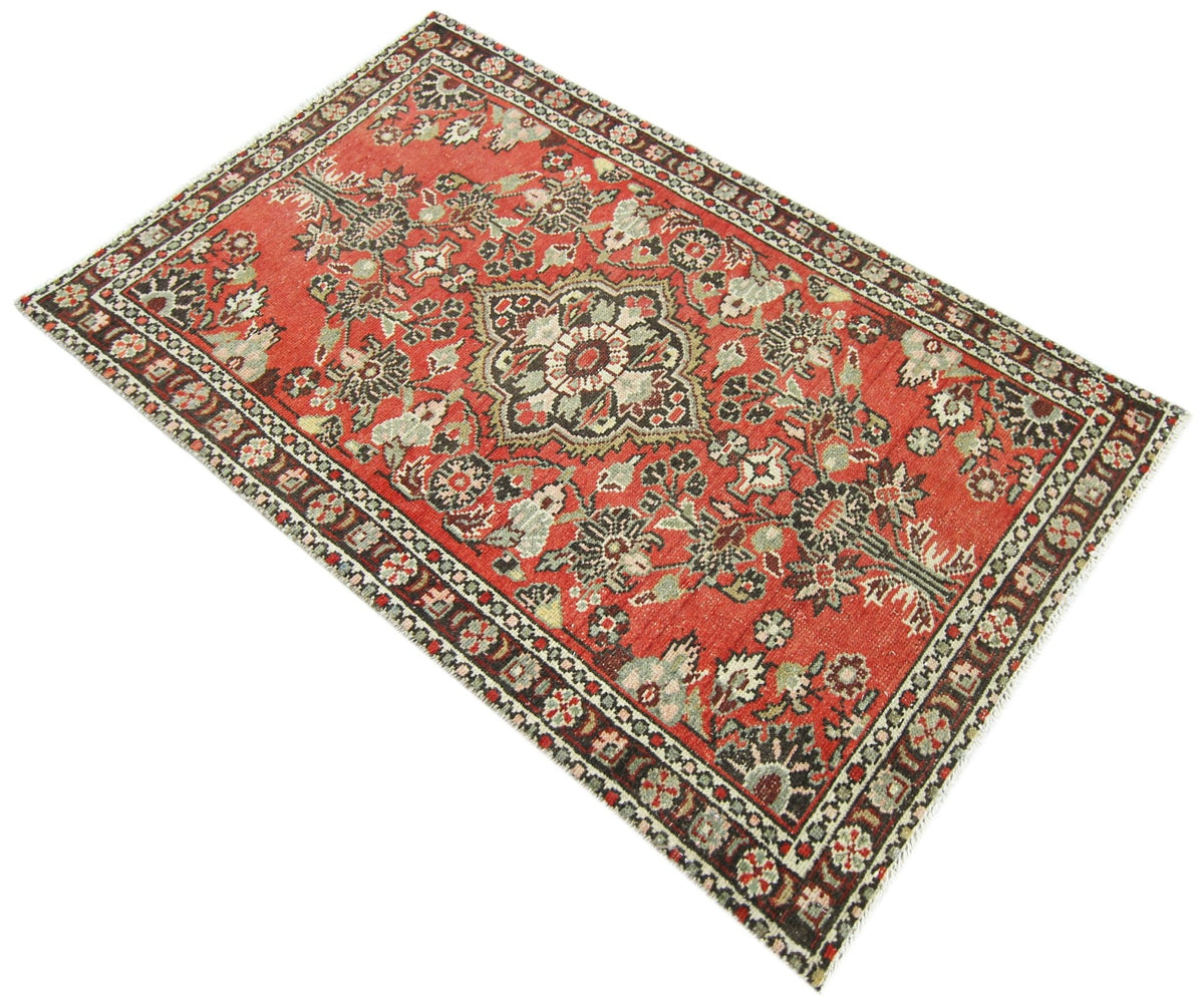 Vintage Persian Sarouk rug featuring a red field with intricate floral patterns, a central medallion, and a decorative border.