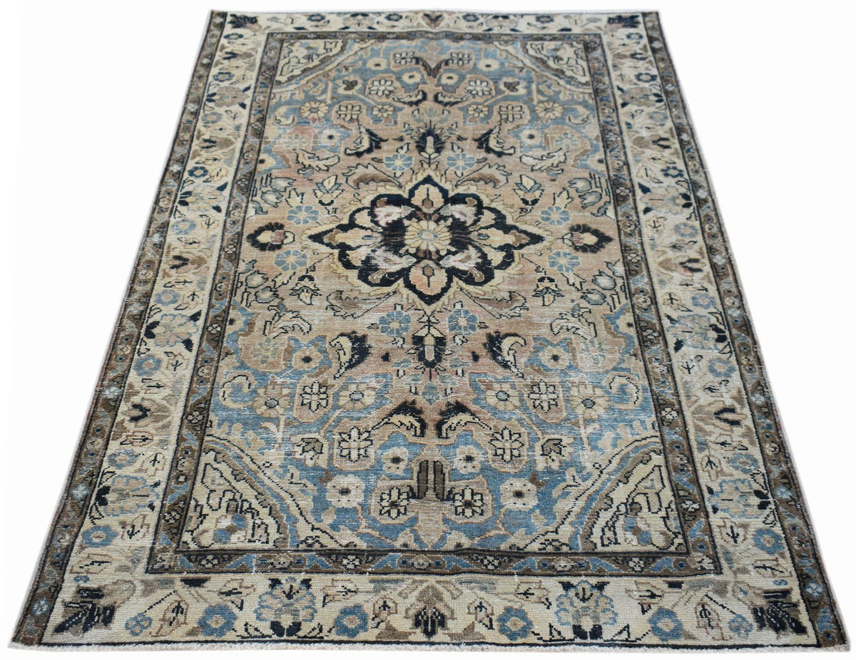 Vintage Persian Sarouk rug with a central medallion, floral motifs, and a palette of navy blue, beige, and soft muted tones.