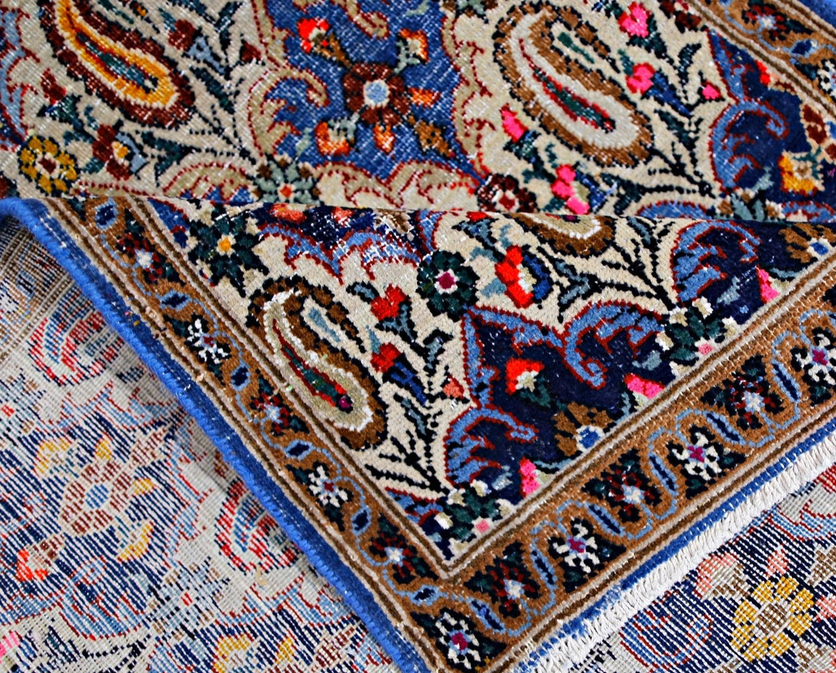 Close-up of a vintage Persian Senneh runner featuring intricate blue, cream, and red Herati and boteh motifs.