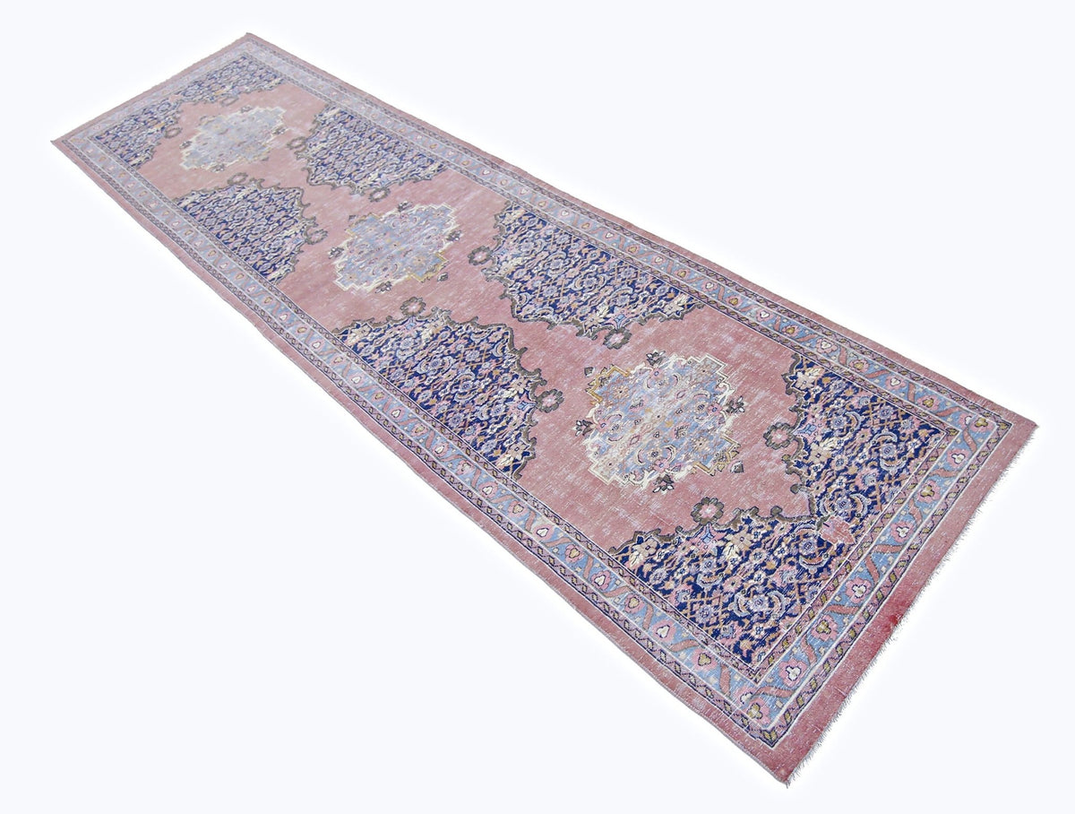 Vintage Persian Senneh runner with a dusty pink field, intricate blue floral motifs, and delicate decorative borders.