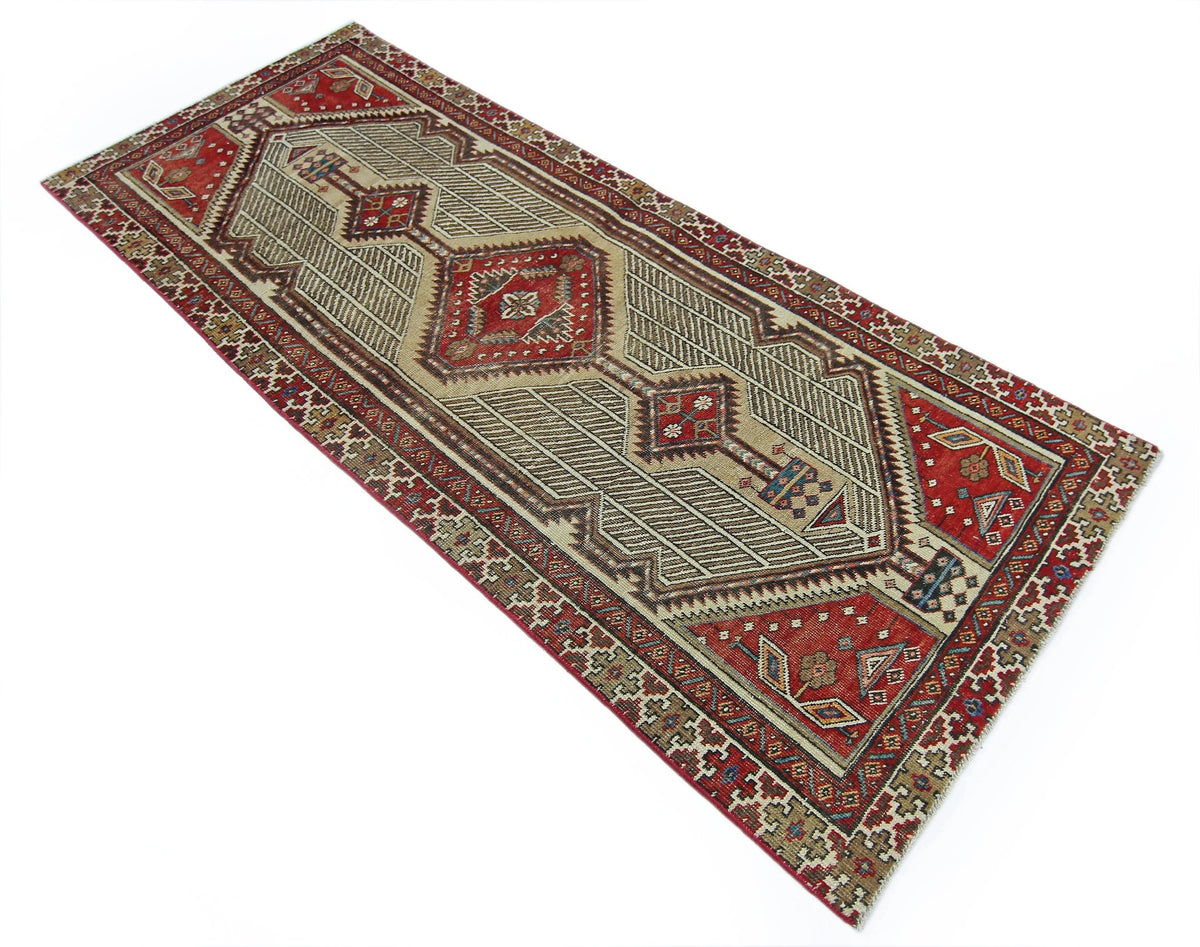A vintage Persian Serab runner featuring a geometric diamond pattern in red, beige, and blue.