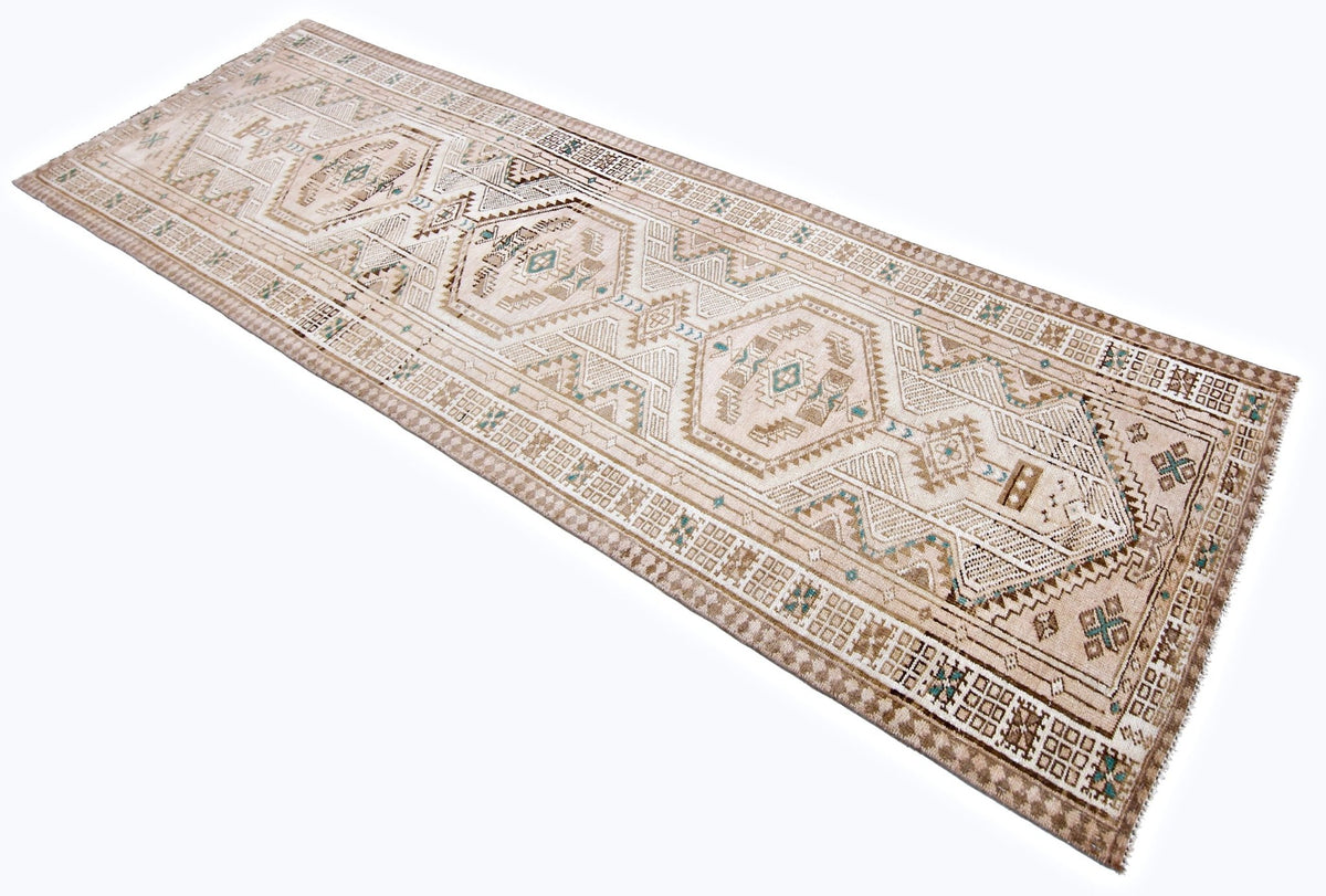 Vintage Persian Serab runner with geometric medallions and stepped diamonds in neutral wool tones on a white background.
