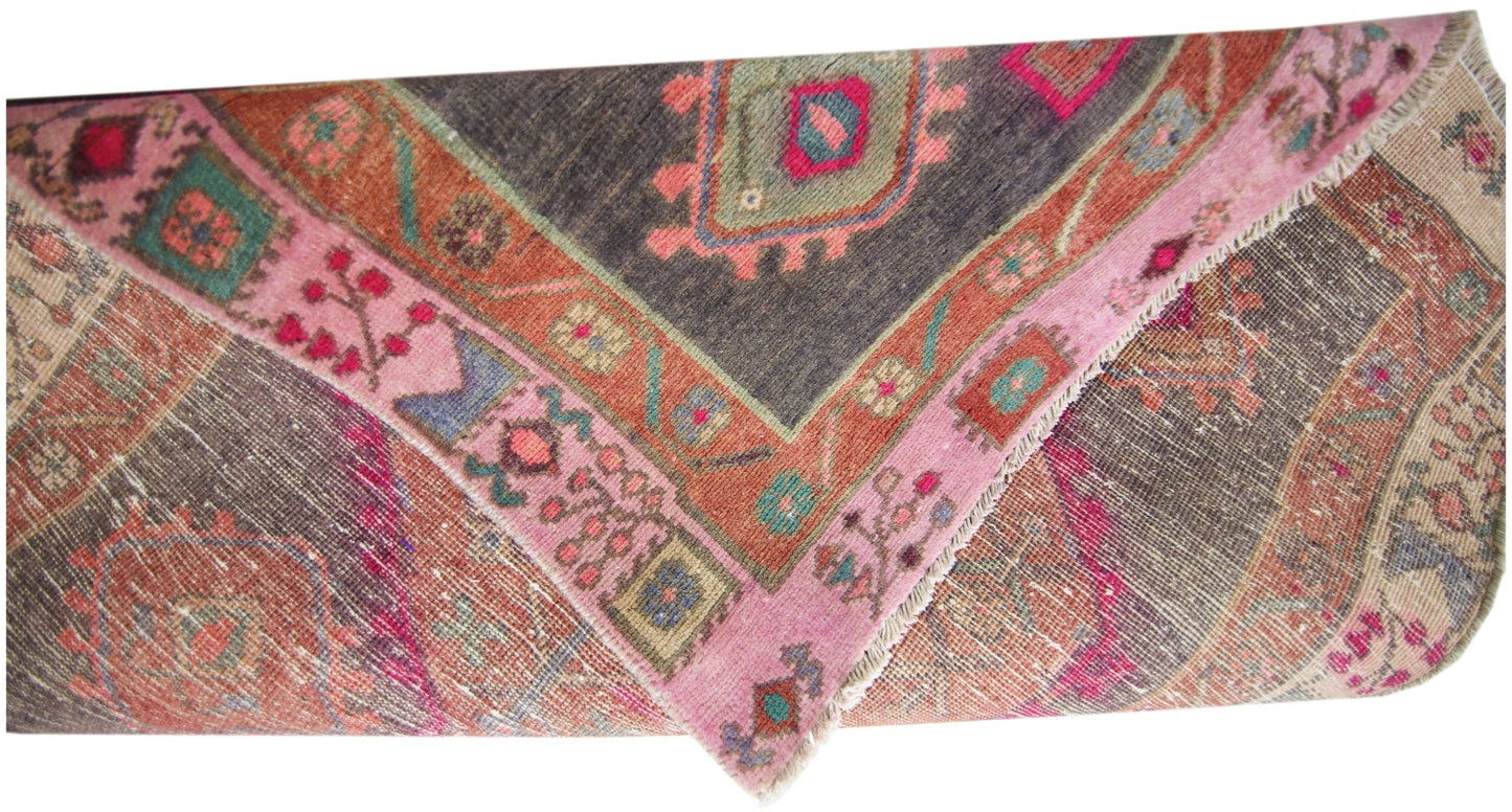 A vintage Persian Hamadan runner featuring a geometric pattern in pink, orange, and dark grey.