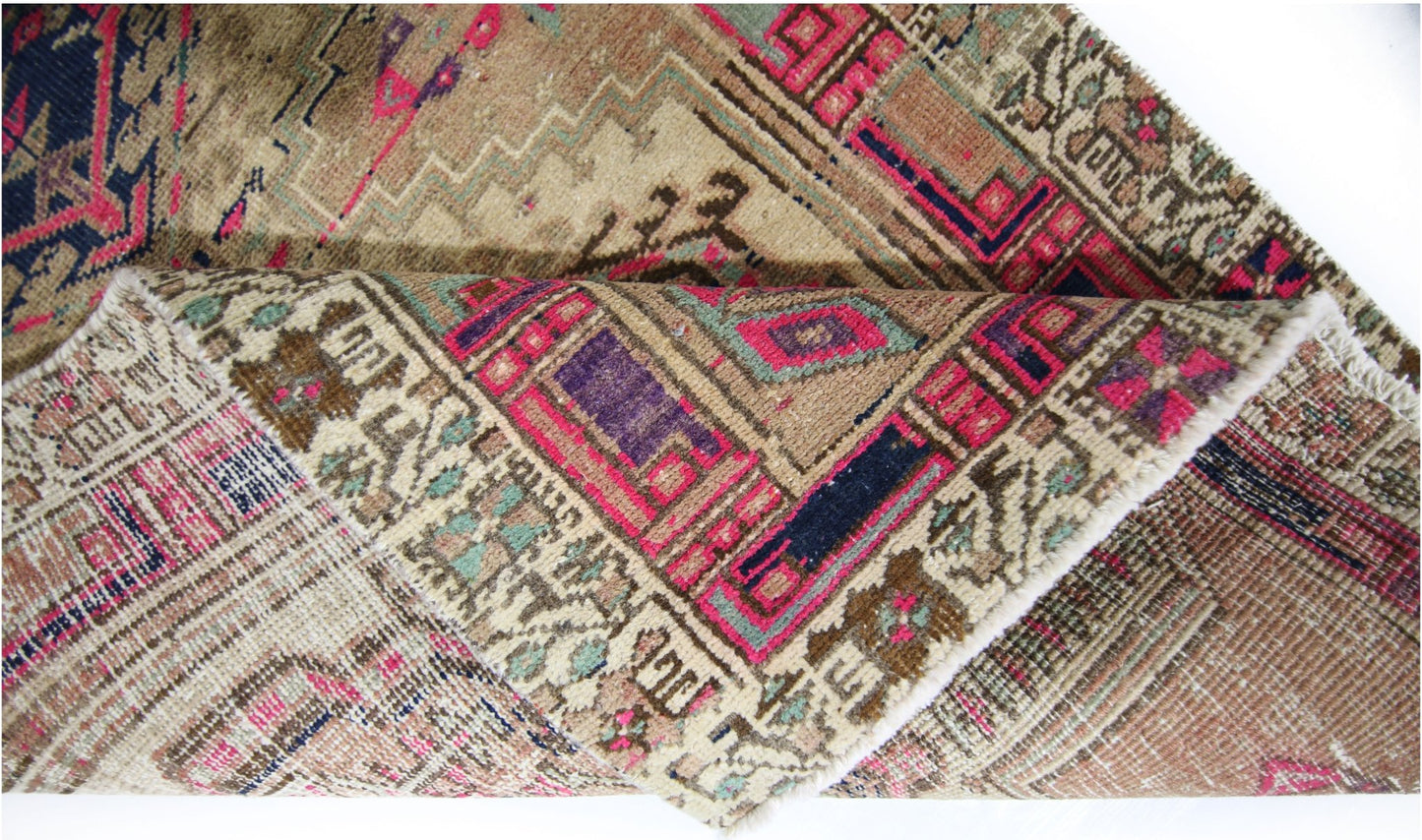 A vintage Persian Hamadan runner featuring intricate geometric patterns in vibrant pink and blue.