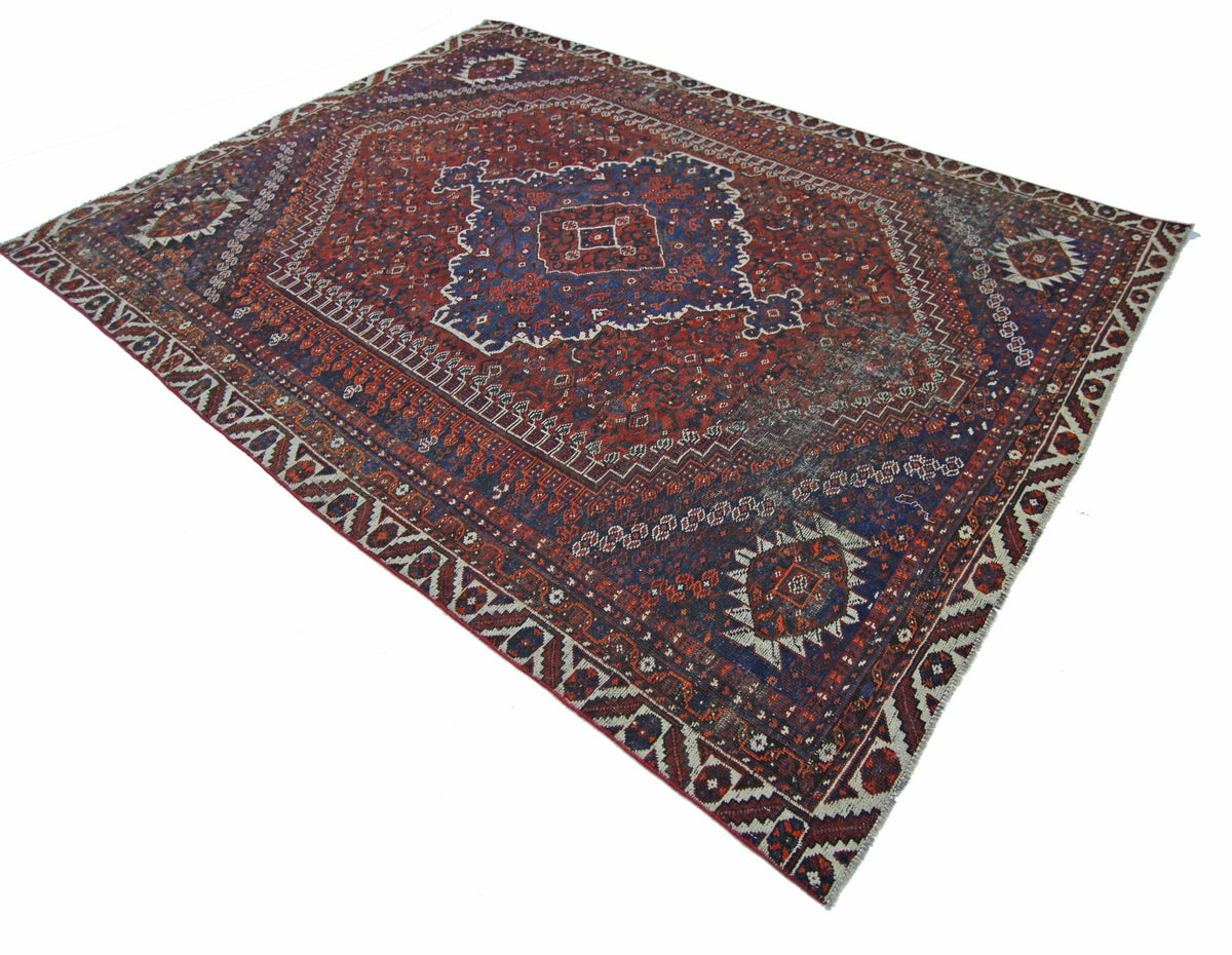 A vintage Persian Shiraz rug featuring a traditional geometric pattern in red and blue tones.