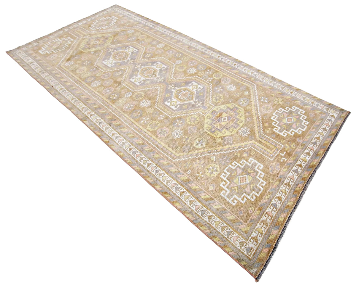 Vintage Persian Shiraz runner in soft beige with geometric diamond medallions, tribal motifs, and a decorative border.