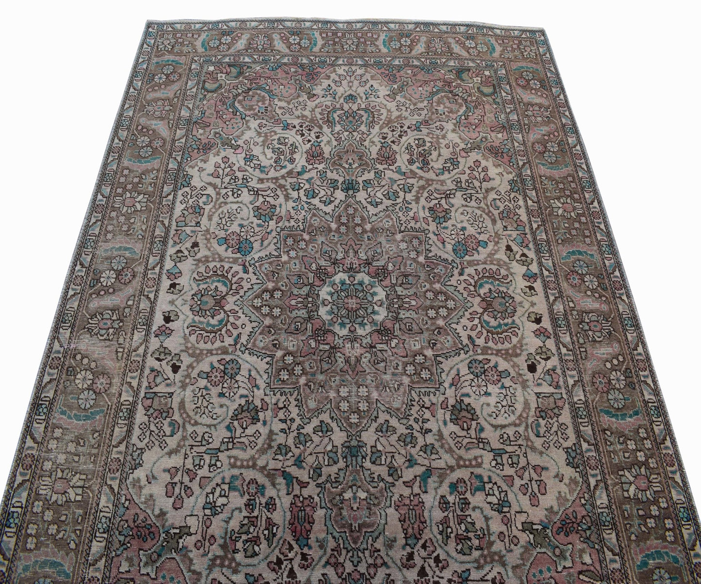 A vintage handwoven Persian Tabriz rug featuring intricate floral patterns in muted earth tones.