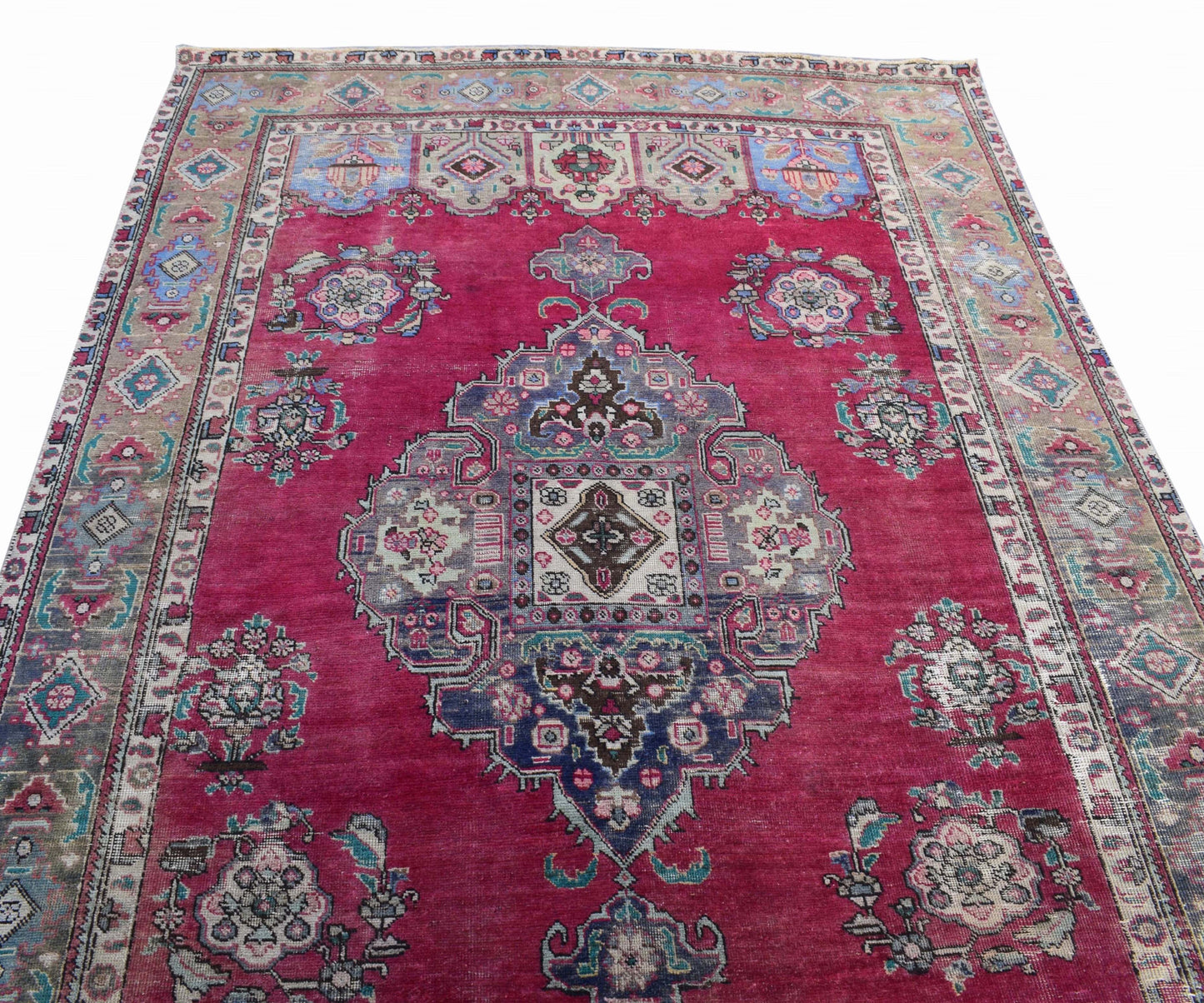 A vintage Persian Tabriz rug featuring a central medallion and intricate floral patterns in red.