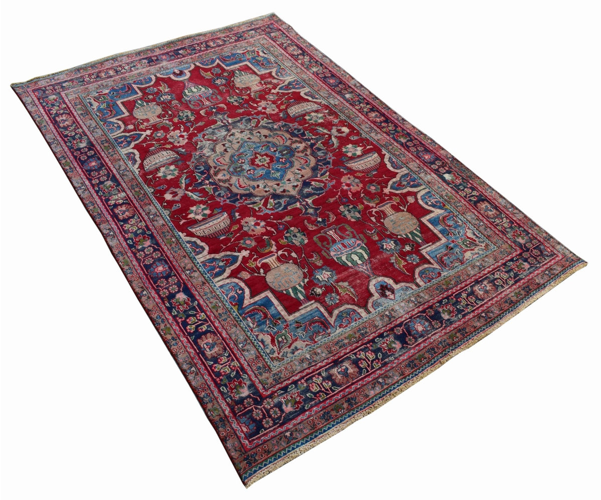 A vintage Persian Tabriz rug featuring a central medallion and intricate floral vase motifs.