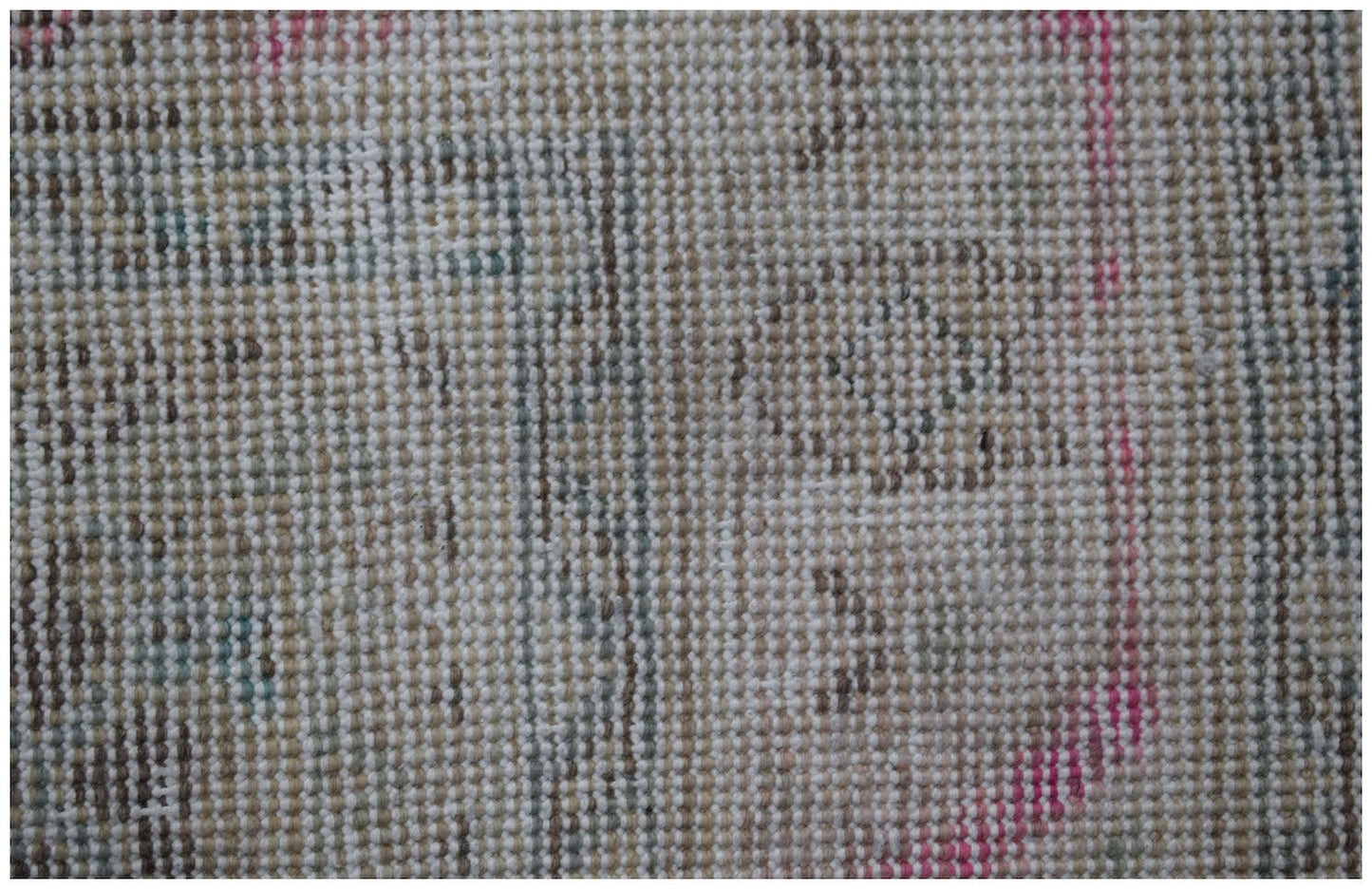 A close-up view of a vintage Persian Tabriz rug featuring a faded, intricate wool pattern.