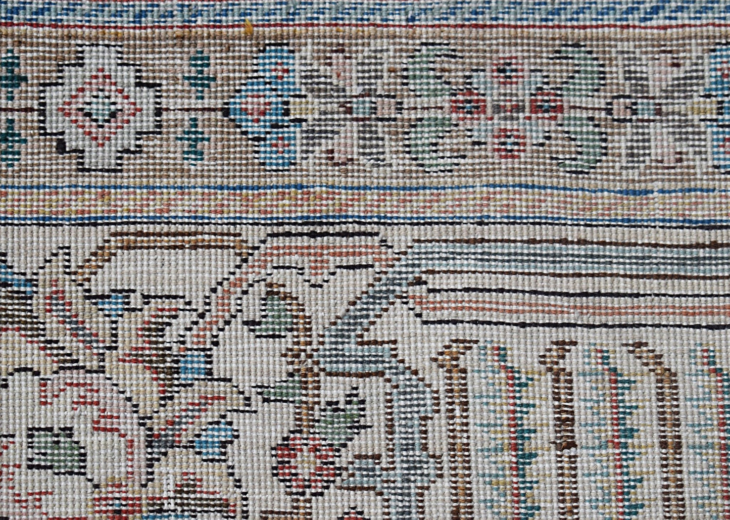 A close-up view of a vintage handwoven Persian Tabriz rug featuring intricate floral patterns.