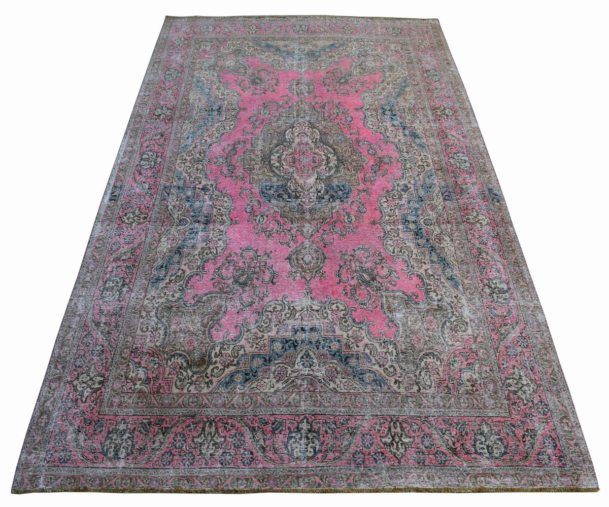 A vintage handwoven Persian Tabriz rug featuring intricate floral patterns in pink and blue tones.